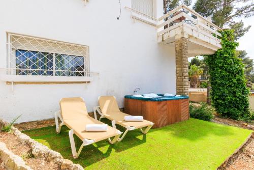 a backyard with two chairs and a hot tub at Casa CODOLAR in Salou
