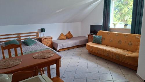 a living room with a couch and a table at Willa Puchatek in Gąski