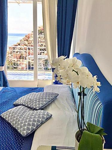 a bedroom with a bed with a vase with white flowers at Santiago vacation home in Positano in Positano