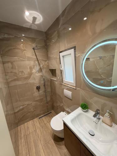 a bathroom with a sink and a toilet and a mirror at Zhiti Waves in Durrës