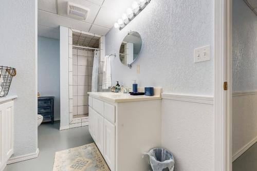 a white bathroom with a sink and a mirror at Sprawling Eufaula Lake Sanctuary w/ Dock! in Texanna