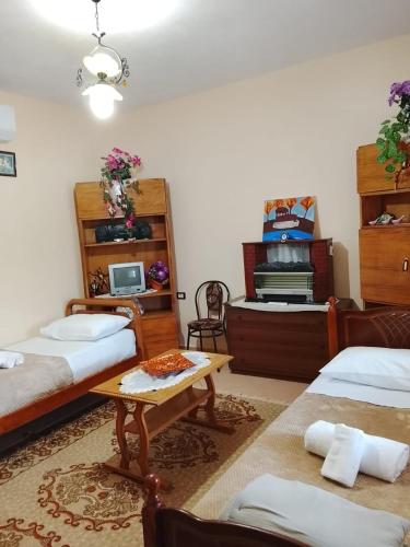 a room with two beds and a table in it at Spring Village Home in Përmet