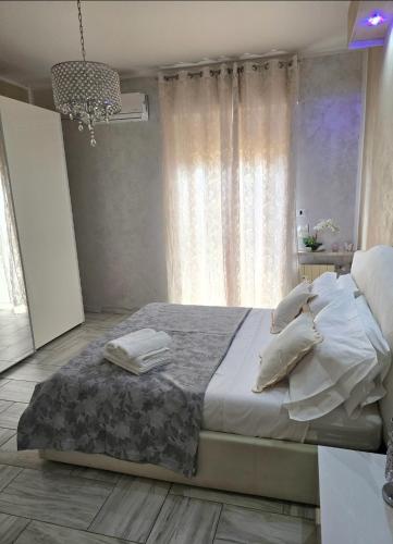 a bedroom with a bed with white sheets and pillows at Alloggio Acqui in Acqui Terme