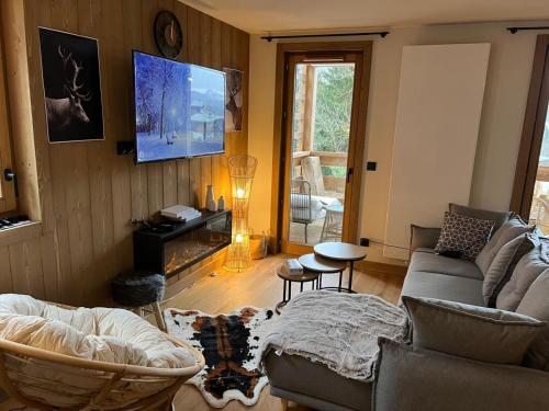 a living room with a couch and a tv at L'Altima Megève in Megève