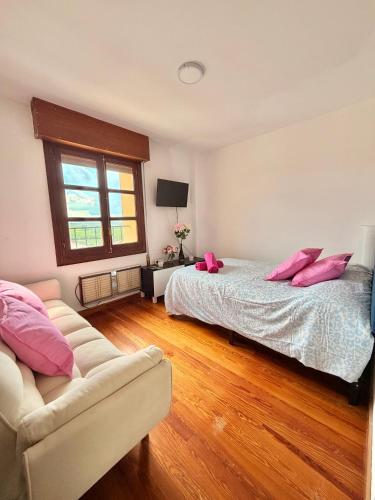 a bedroom with a bed and a couch with pink pillows at Villa Terrazos in Terrazos