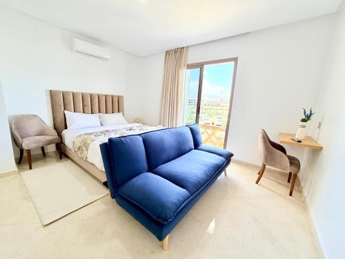 a bedroom with a blue couch in front of a bed at Stay with US in Agadir