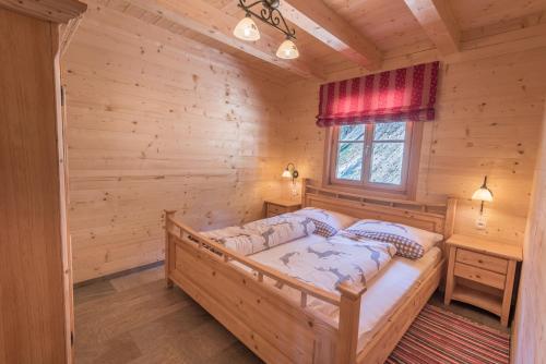 a bedroom with a bed in a log cabin at Steineralm in Schwersberg