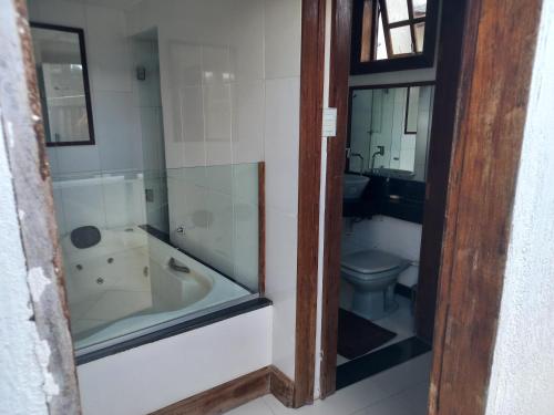 a bathroom with a bath tub and a toilet at Cantinho do Rosário in Diamantina