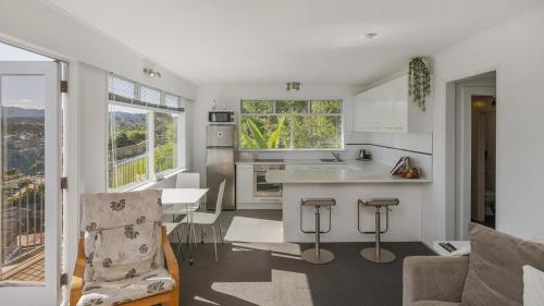 a kitchen and living room with a table and chairs at The Harbour Masters Cottage for Two in Tairua