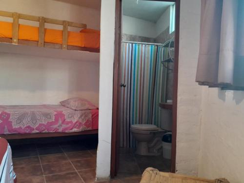 a bathroom with a bunk bed and a toilet in a room at Hospedaje Casa Máncora in Máncora