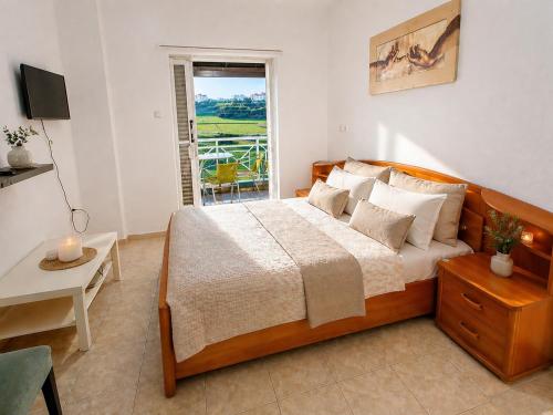 a bedroom with a bed and a table and a window at Flogita 5 Seaside Apartments - 150m from Beach, Ideal for Families & Groups in Flogita