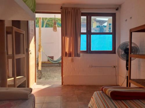 a room with a door and a window and a fan at Hospedaje Casa Máncora in Máncora