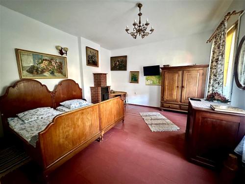 a bedroom with a bed and a table and a chandelier at Dom pod Platanami in Bondyrz