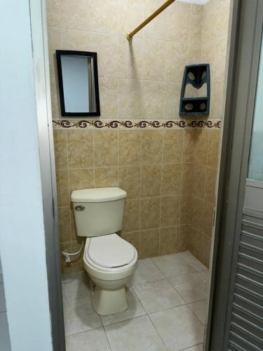 a bathroom with a toilet and a mirror at Cabaña linamar in Coveñas