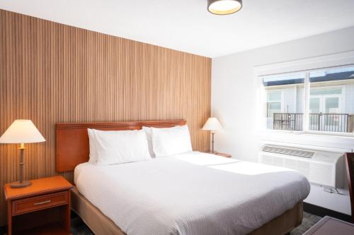 a hotel room with a bed and a window at Travelodge by Wyndham Langley in Langley
