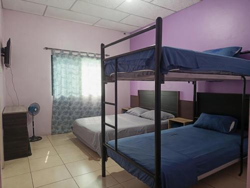ein Schlafzimmer mit zwei Etagenbetten und einem Fenster in der Unterkunft Villa de María in Guayaquil