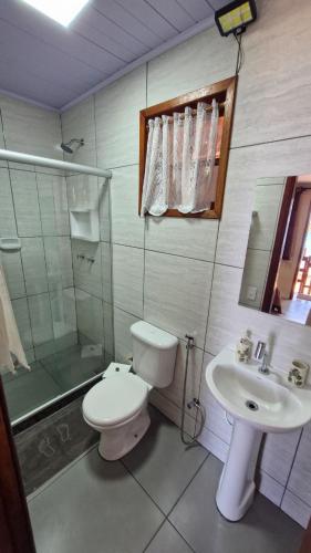 a bathroom with a toilet and a sink and a shower at Suítes Sol e Mar - Pé na Areia- Ilha Grande in Angra dos Reis
