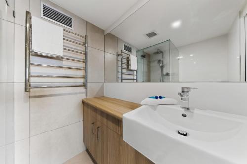 a bathroom with a white sink and a mirror at Spinnaker Quays in Mooloolaba
