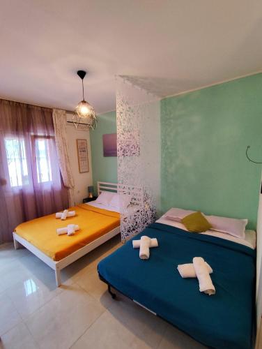two beds in a room with green walls at Sole Di Mare Agia Triada in Agia Triada