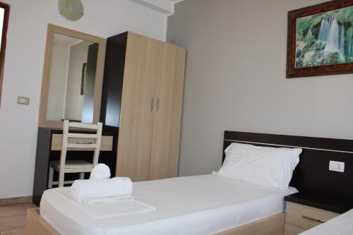 a bedroom with a bed with a chair and a mirror at ANORA Mare Suites in Orikum