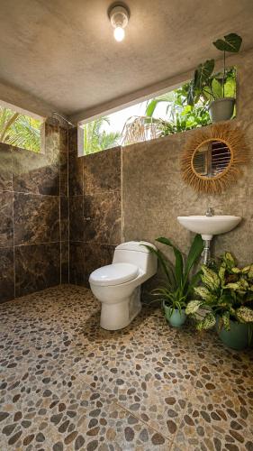 a bathroom with a toilet and a sink and plants at El cielo hotel isla fuerte in Puerto Limón
