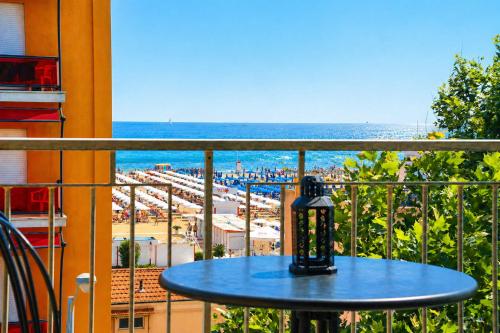 a table on a balcony with a view of the beach at APPARTAMENTI LEONE - Vista Mare - Pet Friendly in Rimini