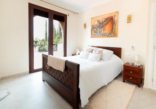 a white bedroom with a large bed and a window at Luxury villa in Azib Oulad Lâdem