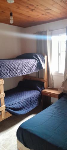 a bedroom with two bunk beds and a window at Los Abuelos in Potrero de Garay