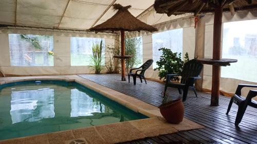 a swimming pool with chairs and a table and an umbrella at Los Abuelos in Potrero de Garay
