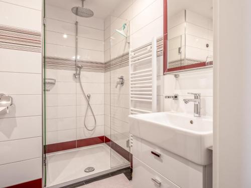 a white bathroom with a shower and a sink at Klein Hintermühltalhof in Itter