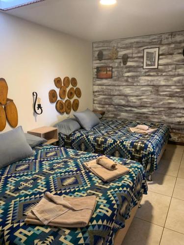 a room with two beds with towels on them at Hostal El Quinde in Salento