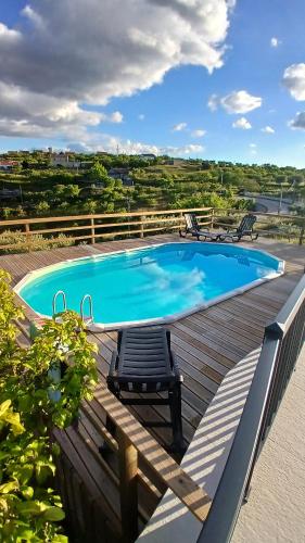 a large swimming pool on a wooden deck with a bench at Casa Do Olival in São João da Pesqueira