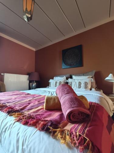 a bedroom with a large bed with towels on it at Aux 1001 Nuits Marrakech's touch in Chapelle-lez-Herlaimont
