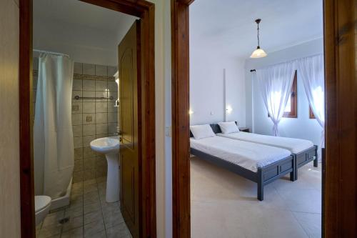 a bedroom with a bed and a tub and a sink at Sifakis House in Parga