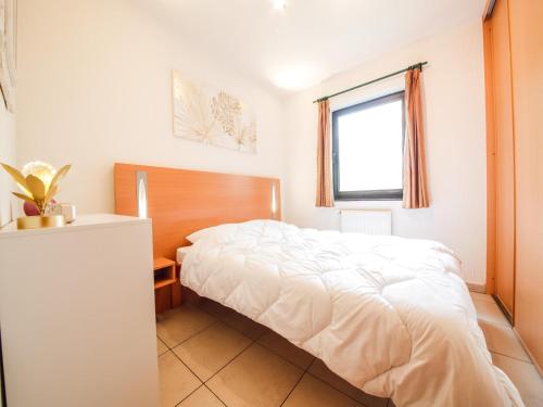 ein Schlafzimmer mit einem weißen Bett und einem Fenster in der Unterkunft Castelgolf in Barvaux