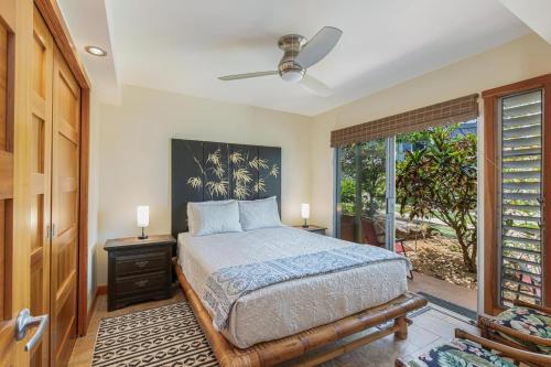 a bedroom with a bed and a large window at Puamana 19C in Princeville