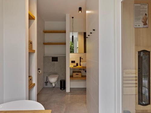 a bathroom with a toilet and a sink at Het Duinnest in Kamperland