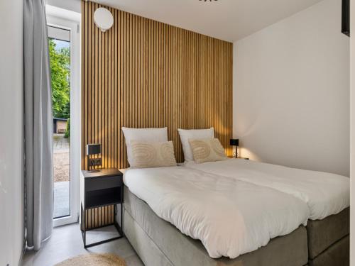 a bedroom with a large bed and a window at Het Duinnest in Kamperland