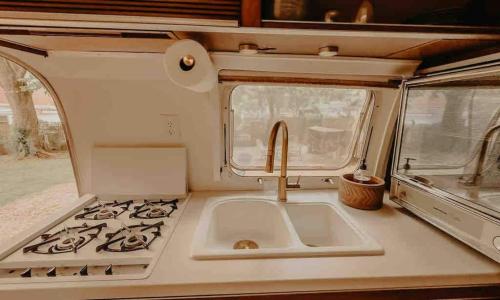 a kitchen with a sink and a stove in an rv at Urban Airstream Retreat in Memphis