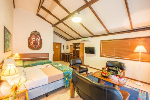 a bedroom with a bed and a table and chairs at Madang Resort in Madang
