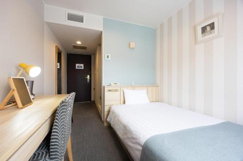 a hotel room with two beds and a desk with a bed istg at Hotel St Palace Kurayoshi in Kurayoshi