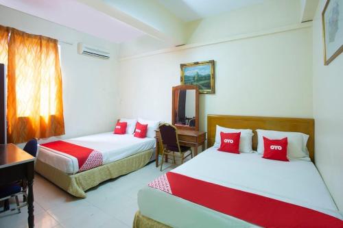a bedroom with two beds and a desk and a table at perfect class hotel in Kuala Lumpur