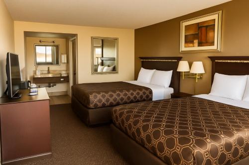 a hotel room with two beds and a flat screen tv at MHO Hotel Eloy Casa Grande Near I-10 in Eloy