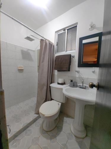 a bathroom with a white toilet and a sink at Ribera Dorada in Monterrey
