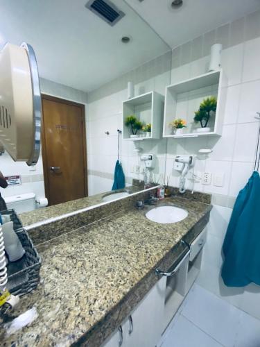 a bathroom with a granite counter top and a sink at Tropical Executive Hotel in Manaus