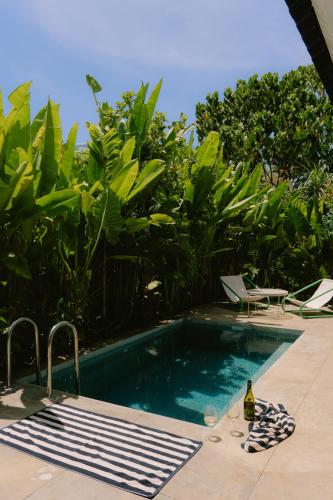 a swimming pool with a bottle of wine and a table and chairs at Ananda House in El Nido