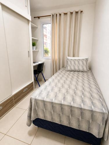 a bedroom with a bed and a desk and a window at Apartamento perto do aeroporto e do estádio do mangueirão in Belém