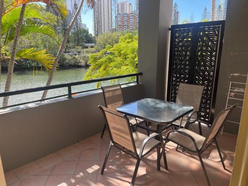 a table and chairs on a balcony with a view of a river at Serenity in Surfers Paradise in Gold Coast