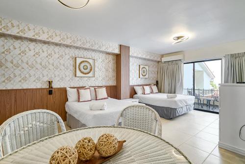 a hotel room with two beds and a balcony at Roy Arias Suites & Residences in Santo Domingo