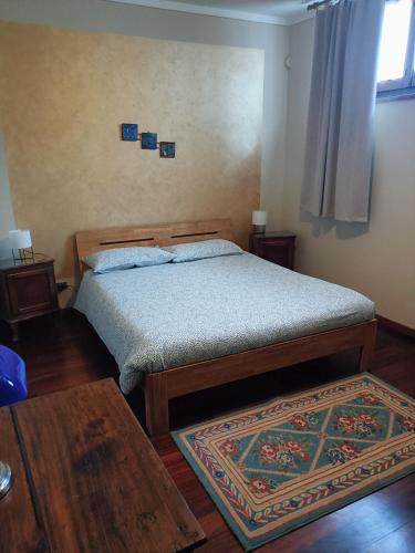 a bedroom with a bed and a rug at Casa Vicino in Carrù